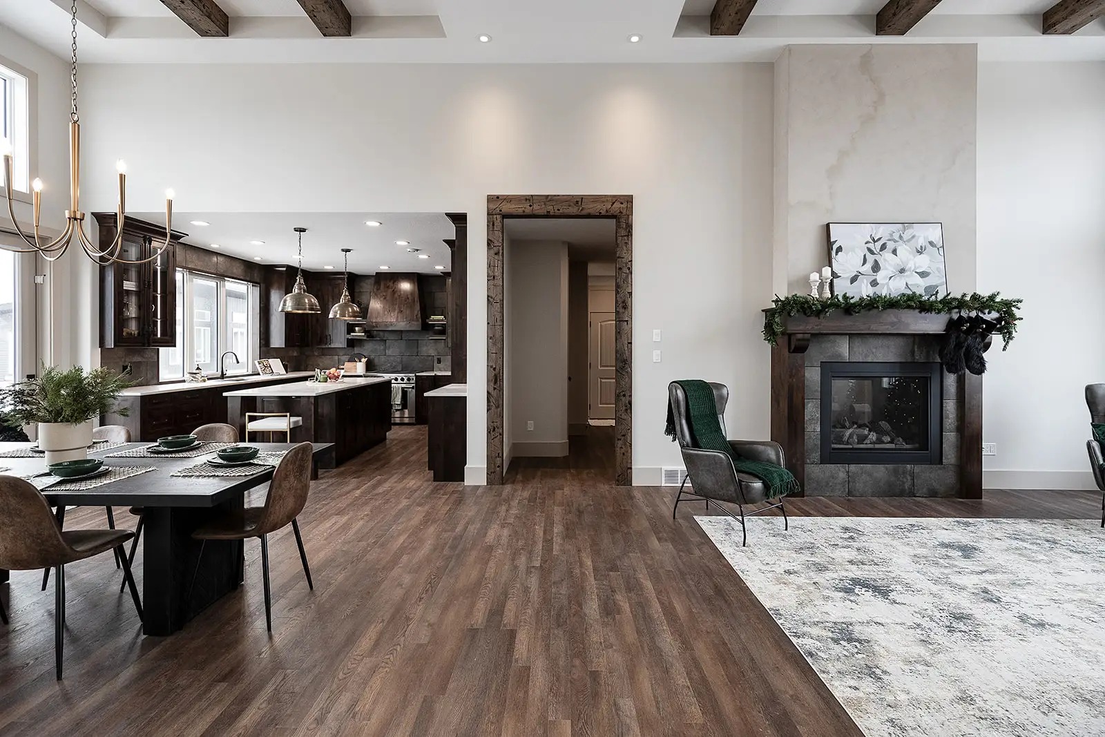 Spacious modern home interior featuring hardwood floors, a kitchen with dark wood cabinets, a dining area, and a cozy living room with a fireplace.