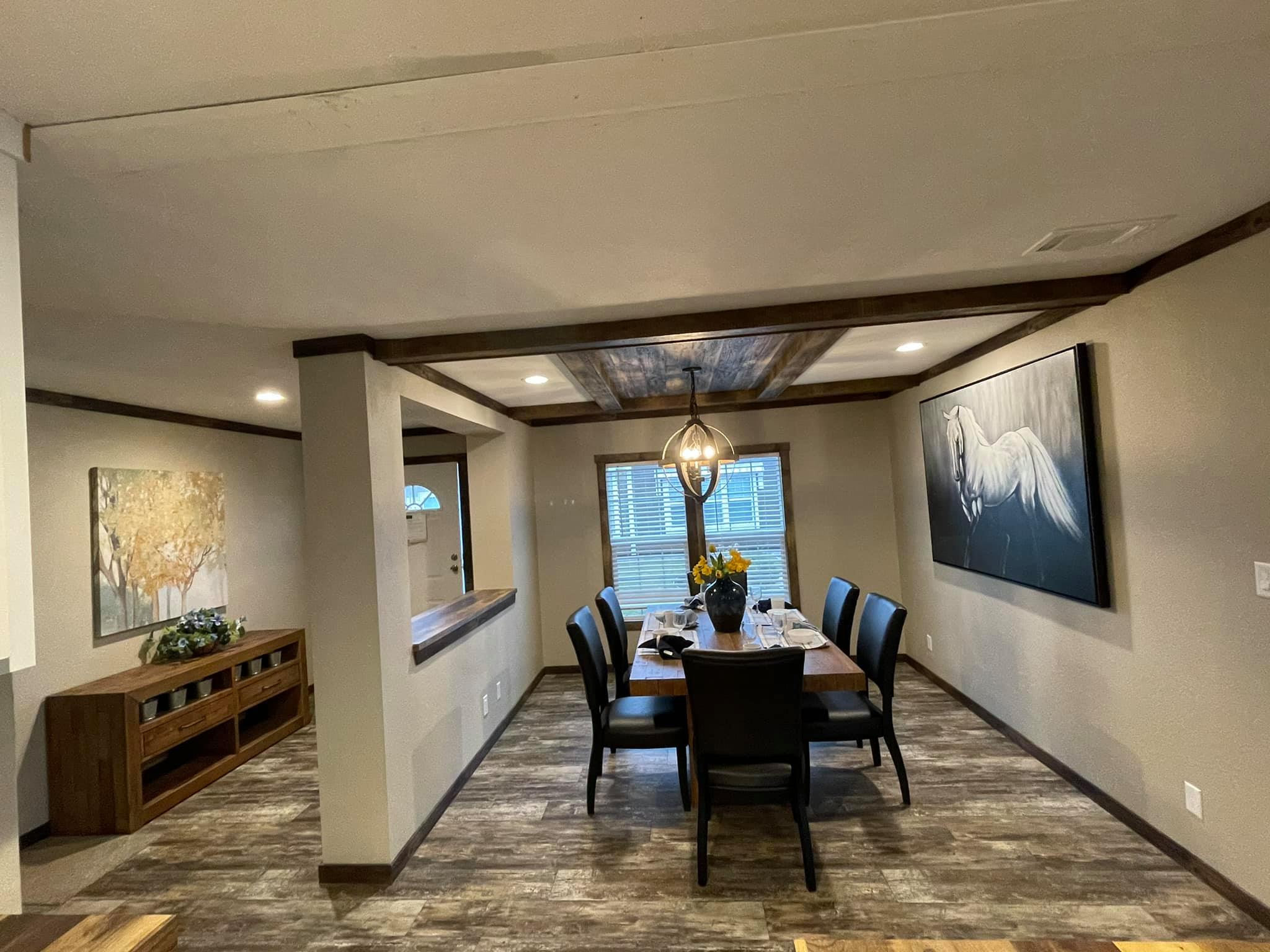 Modern dining room with wood accents featuring a table set for six. A pendant light hangs above, and horse artwork adorns the wall, creating a warm, inviting atmosphere.
