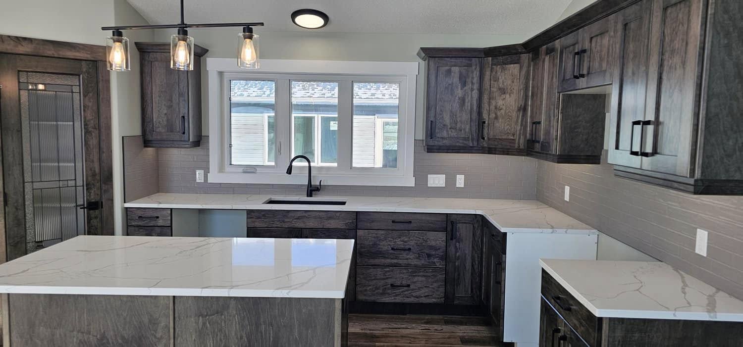 Modern kitchen with dark wood cabinets, marble countertops, and a center island. Three pendant lights hang above. Sunlight streams through a window, creating a sleek, clean atmosphere.