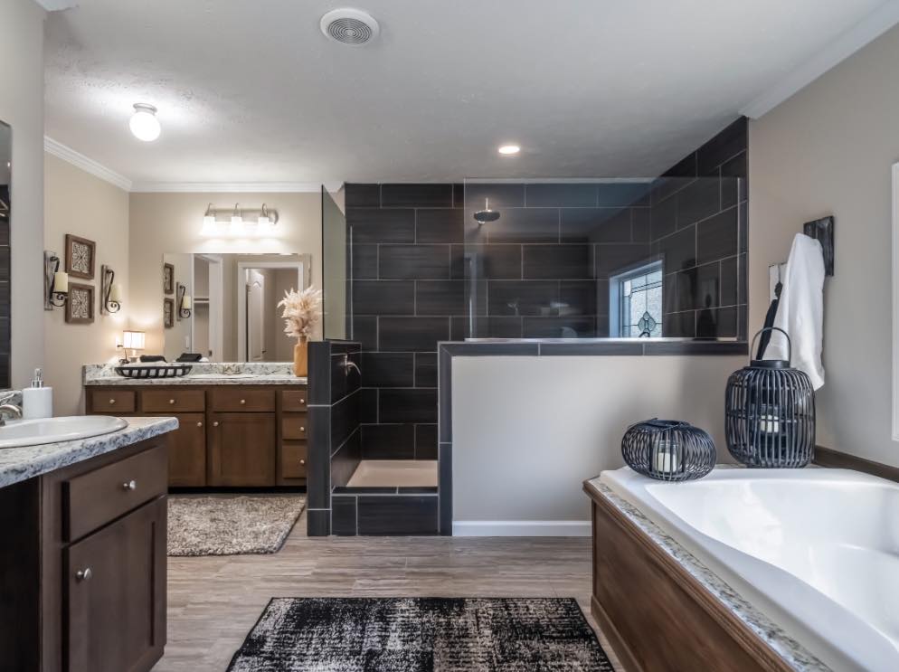 Modern bathroom with dark-tiled walk-in shower, wooden cabinets with marble countertops, a soaking tub, and decorative lanterns. Elegant and tranquil.