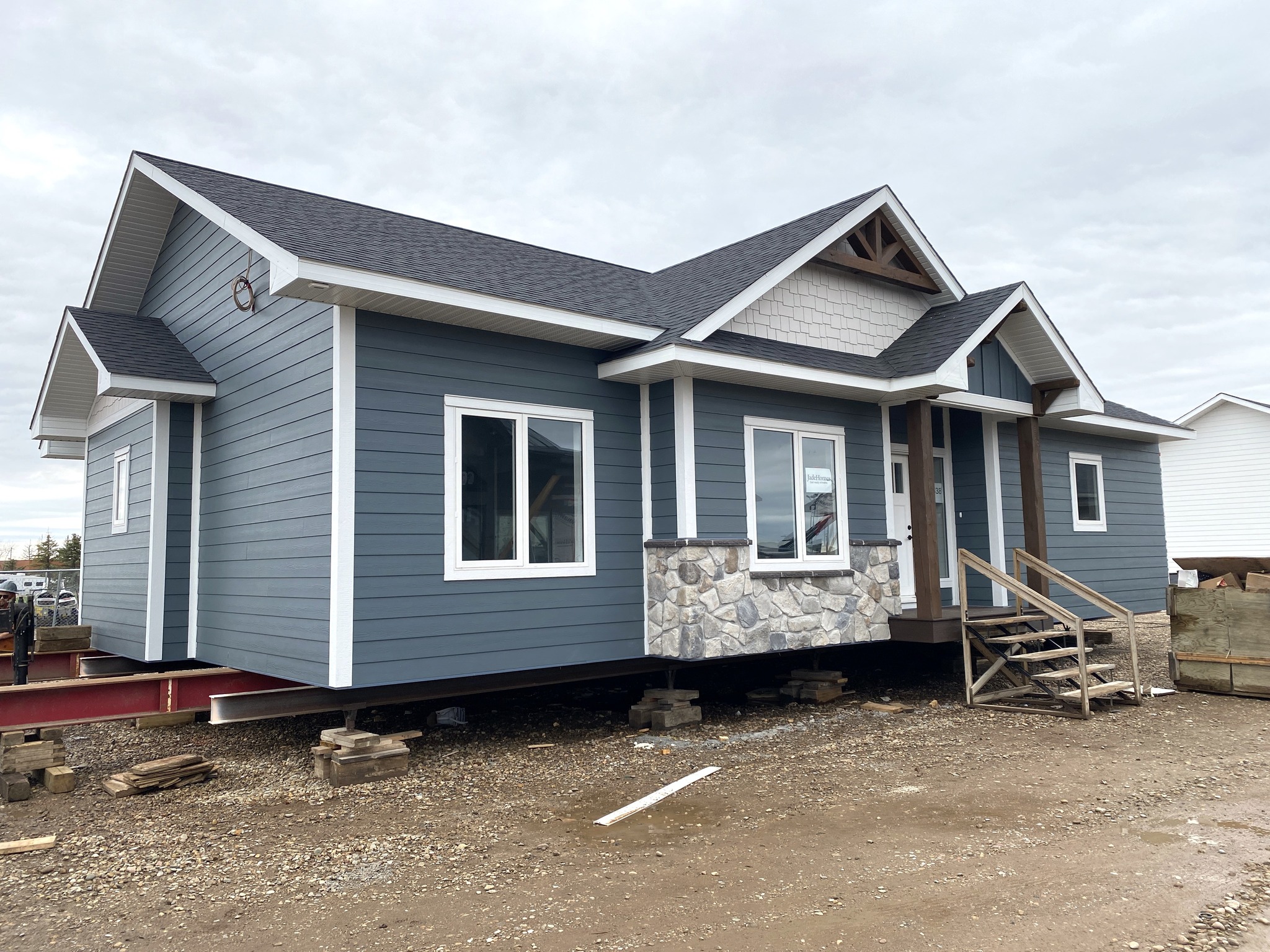 A wooden sliding barn door partially open, revealing a bathroom with a modern sink and dark cabinetry. Soft lighting and a minimalist style.