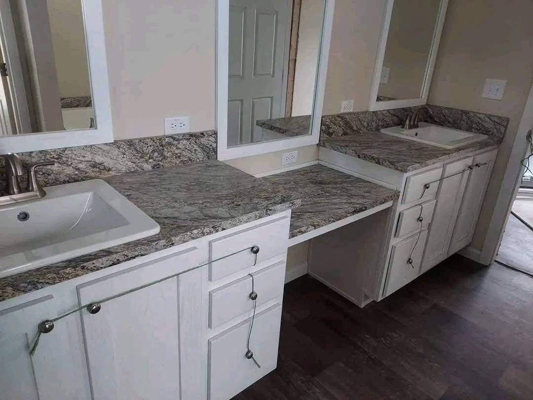 Double bathroom vanity with marble countertops and white cabinets, two rectangular mirrors, one sink on each end. Neutral tones; elegant and modern.