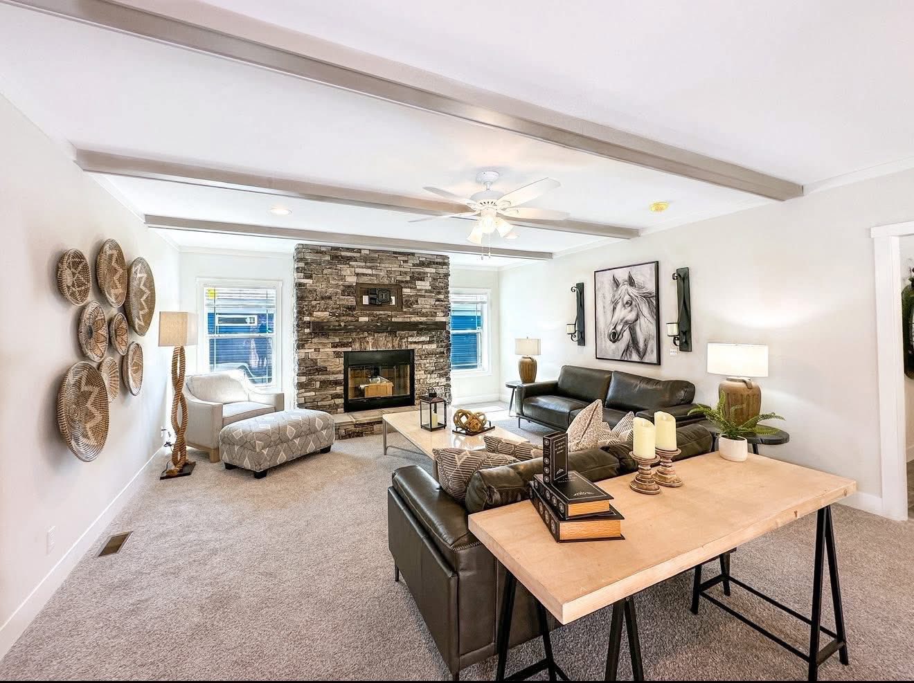 Stylish living room with neutral tones, featuring a stone fireplace, leather couches, wall art of a horse, and woven basket decor. Cozy and inviting.