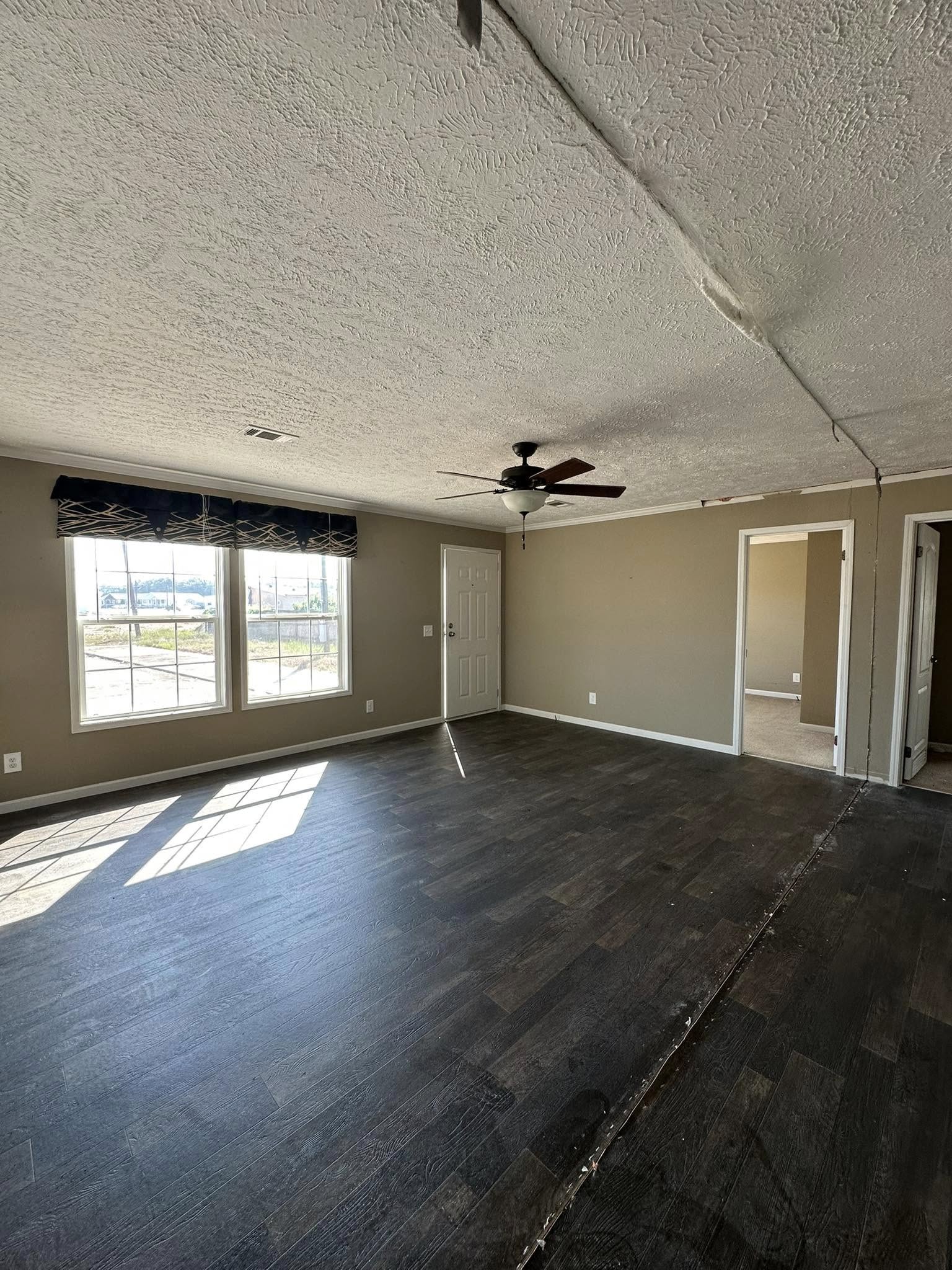 Narrow, empty walk-in closet with light wooden paneling, dark floor, and white wire shelving. A single ceiling light adds minimal brightness.