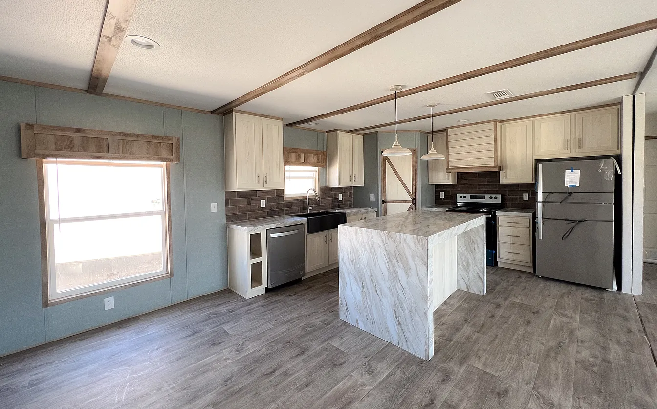A modern kitchen with marble countertops, wooden cabinets, stainless steel appliances, and light wood flooring. Two pendant lights hang over the island.