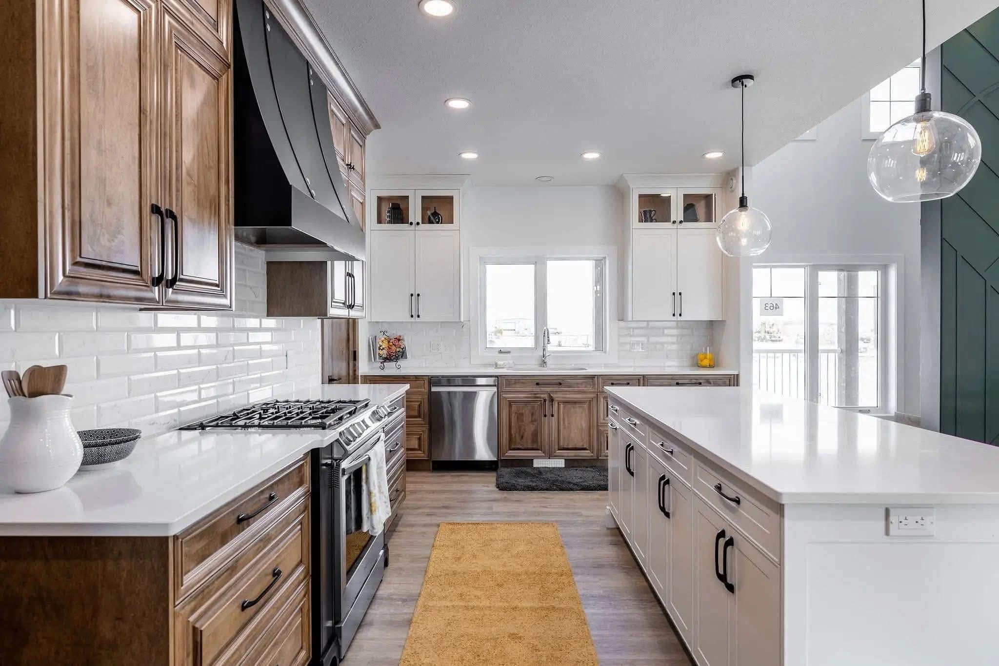 Modern kitchen with warm wooden cabinets and sleek white countertops. Features a gas stove, subway tile backsplash, pendant lighting, and a cozy yellow rug. Bright and inviting atmosphere.