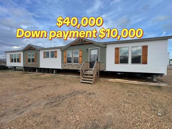 A large mobile home with three sections is set up on a gravel lot under a cloudy sky. Text overlay reads, "$40,000 Down payment $10,000" in bold yellow letters.