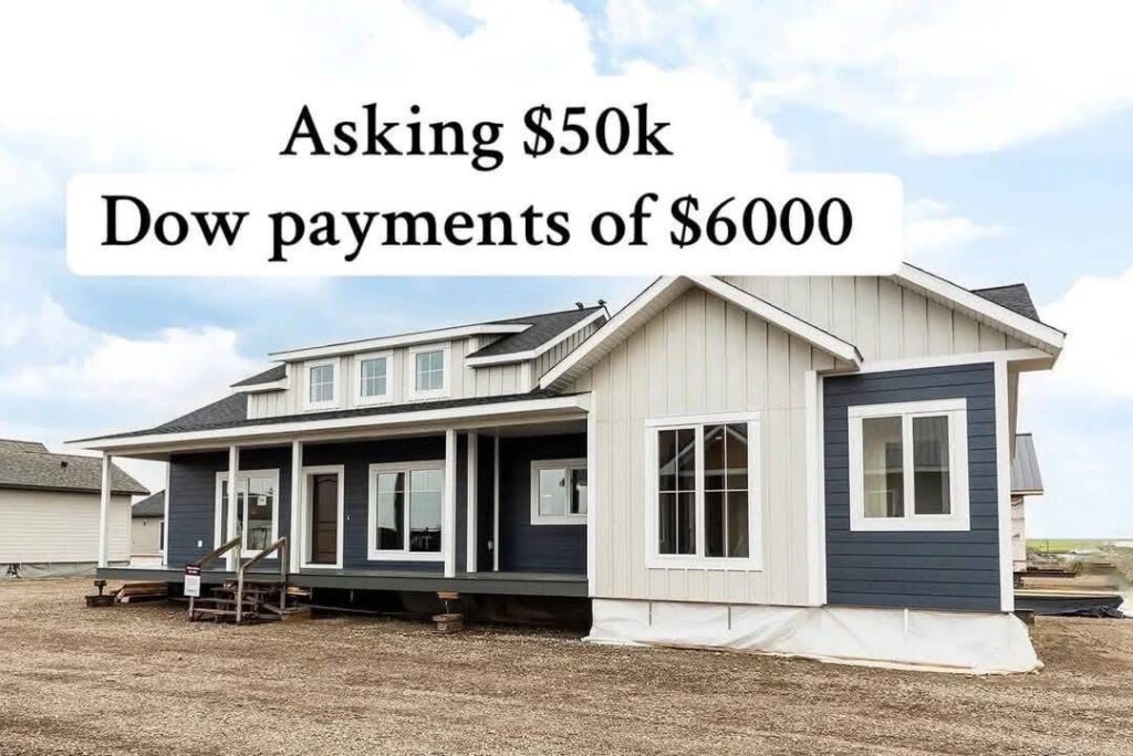 A modern, two-story, prefabricated house with dark blue and white siding. Text above reads, "Asking $50k, Dow payments of $6000." Overcast sky.